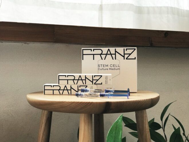 White packaging with the words Franz across it all sitting on a wooden stool
