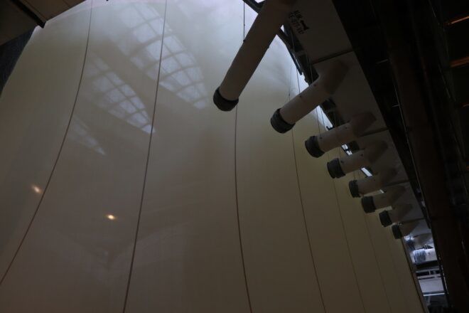 A white wall with poles sticking out of it from the top