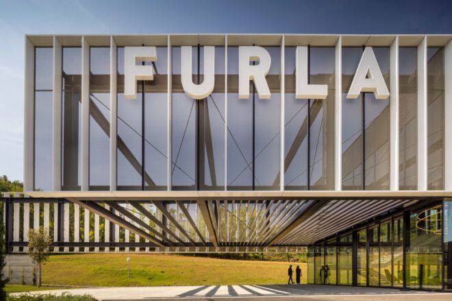 A geometric building that reads FURLA across from it in white bold lettering