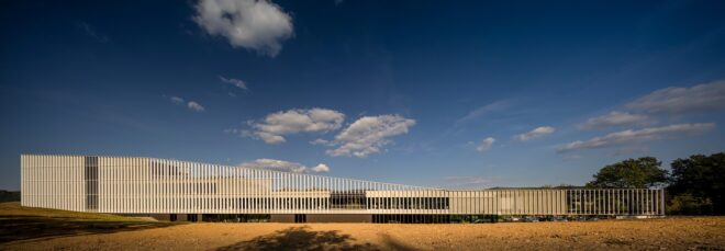 A long stretch of a the Furla Headquarters feature vertical bars that slowly get smaller moving from left to right