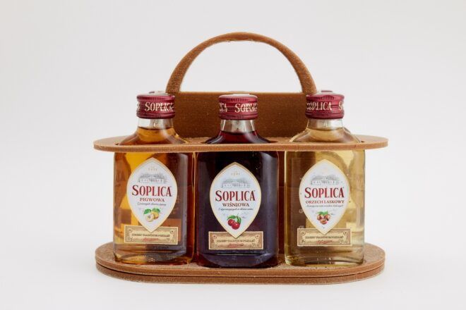 Three different syrup bottles in a display container that has a handle