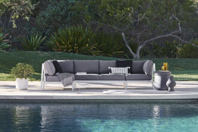 A grey sofa sitting behind a pool