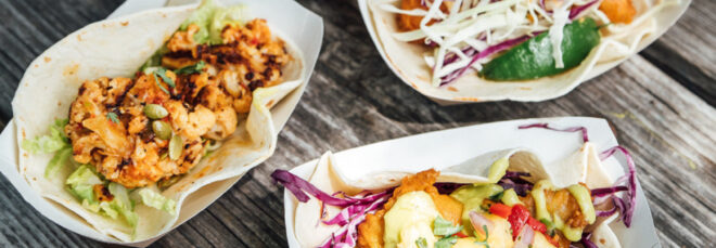 Three small trays filled with various tacos