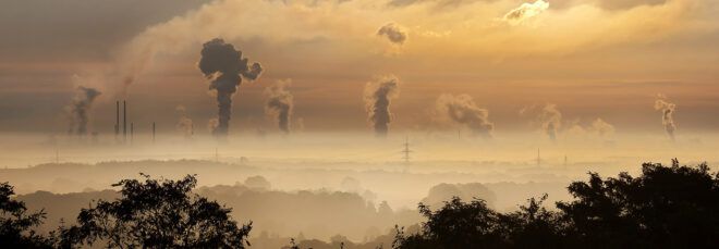 A landscape of factory emitting smoke that contributes to climate change.