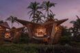 A bamboo structure on the beach at dusk.