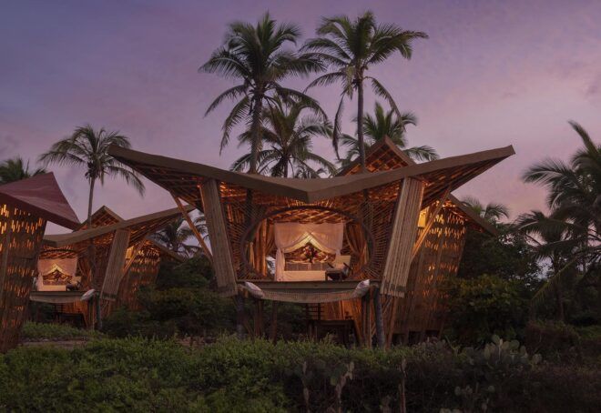 A bamboo structure on the beach at dusk.