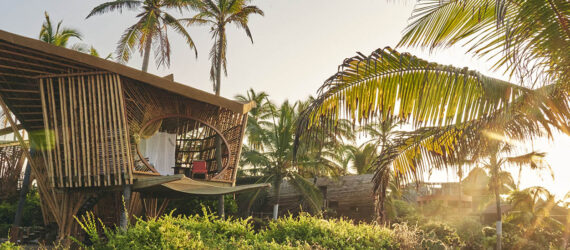 Two bamboo structures on the beach.