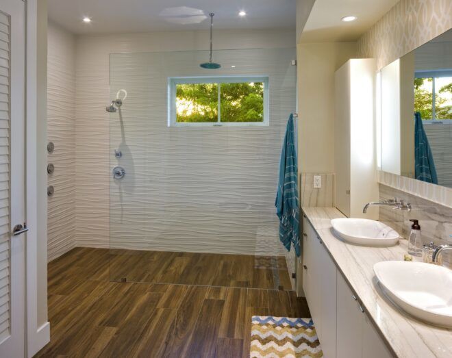 A bathroom with two sinks on the right and a shower area in the background