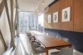 A dining area with a long table surrounded by chairs.