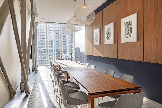 A dining area with a long table surrounded by chairs.