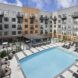 A pool surrounded by an apartment building.