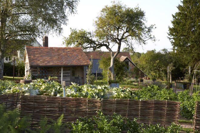 A small building surrounded by a garden.