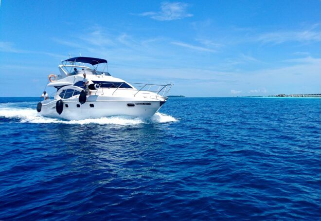 A single white yacht cruising on a blue ocean