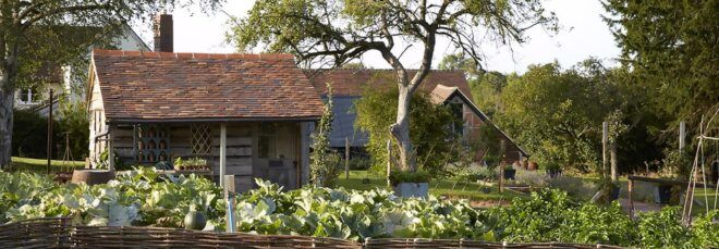 A small building surrounded by a garden.
