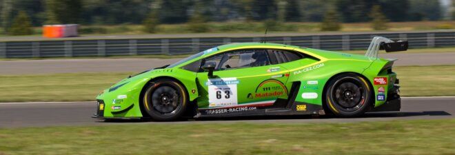 A green vehicle with a sticker that reads 63 on it racing on a track