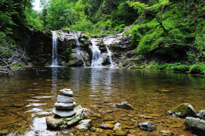 A waterfall filling up a lake full of rocks