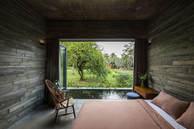 A bedroom with an open window of the entire wall out to the pond