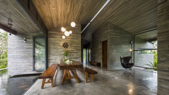 A dining area with a long rectangle wooden table and two benches on either side of it