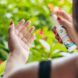 A person spraying a reef-safe sunscreen product into their hand.