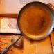 A cast iron pan standing in its packaging