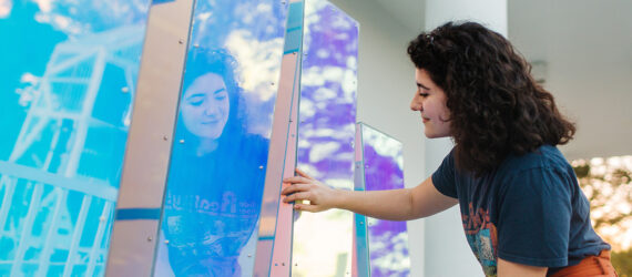 A person touching the TIDAL sculpture which look like rectangular holographic blocks