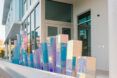 A holographic statue of rectangle blocks in varying heights sits against a building