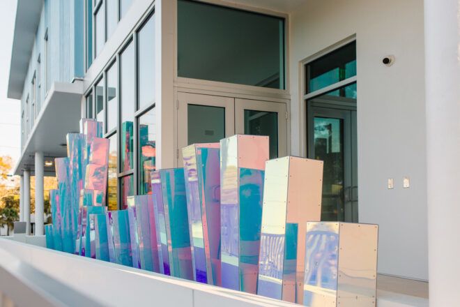 A holographic statue of rectangle blocks in varying heights sits against a building