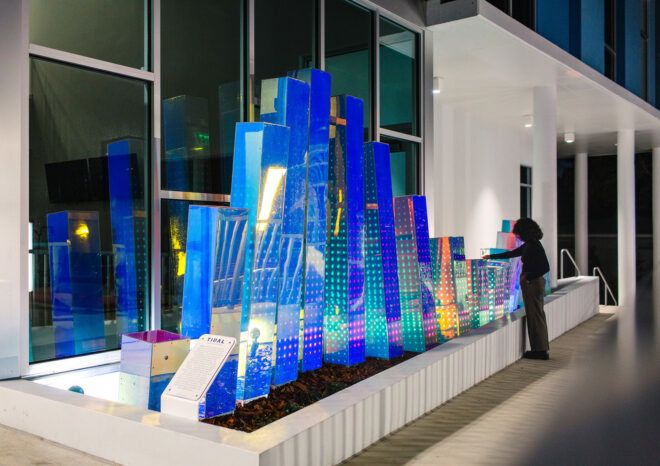 Inside a building a holographic light up artwork looks like rectangle blocks in varying heights
