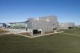 A large gray building that sits in a grass field