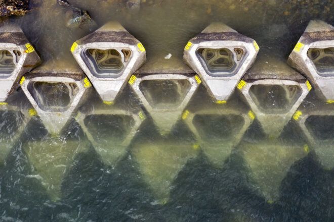 Concrete coastalock elements in rows submerged in seawater