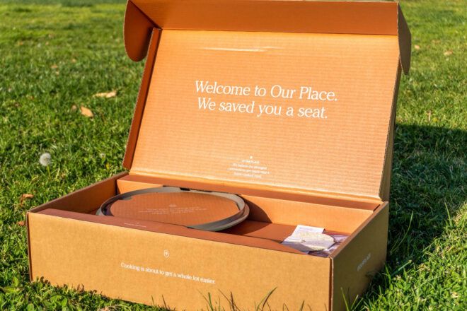 A cardboard box opened up to read "Welcome to Our Place. We save you a seat."