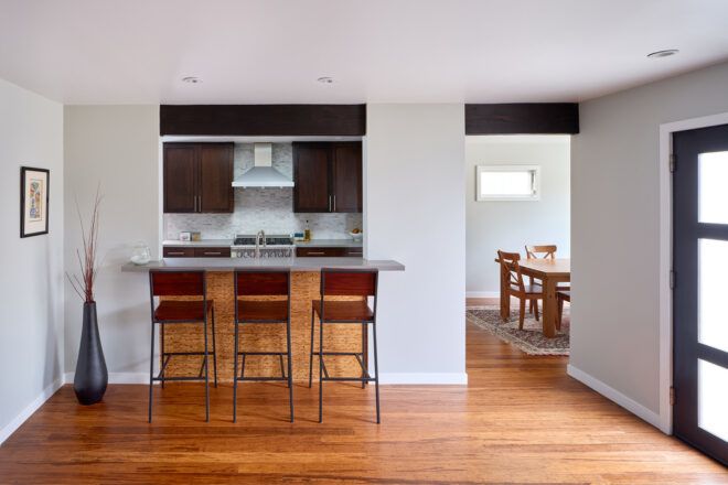 Outside a kitchen remodel showing wood floors and stools at a bar.