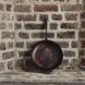 A cast iron pan leaning against a brick wall