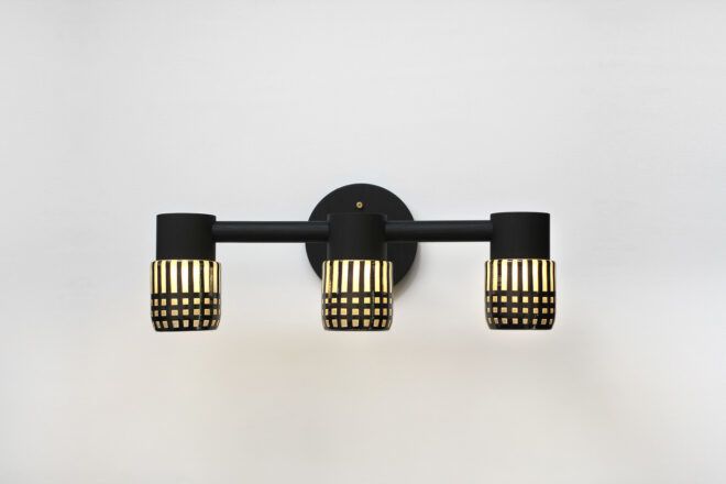 A three light system hangs against a white wall