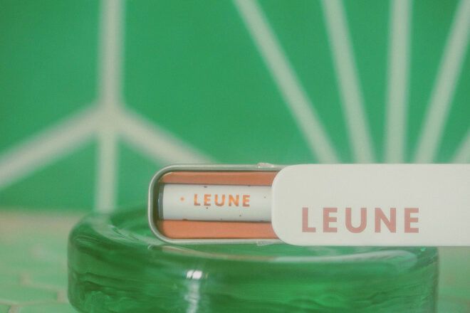 A light pink LEUNE container against a green backdrop