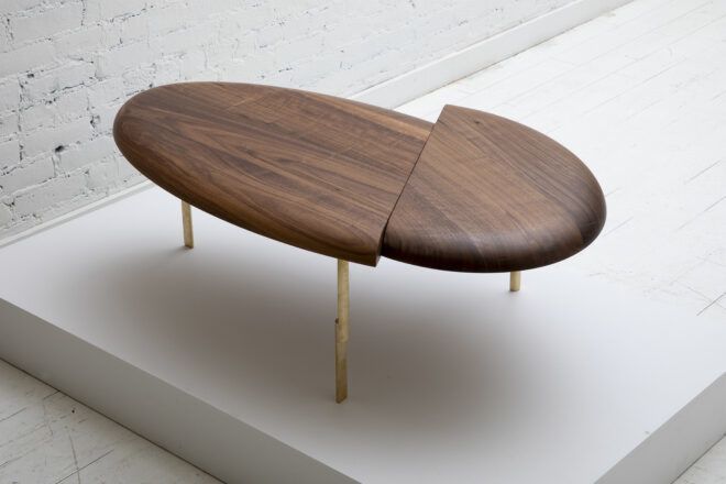 A wooden oval table cut at the top so it is off alignment