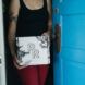 A person leaning against a blue door holding a white box with the initials RR on it