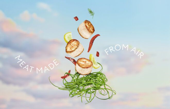 Scallops made from plants are tossed up with chilis, lemon wedges and greens at the bottom