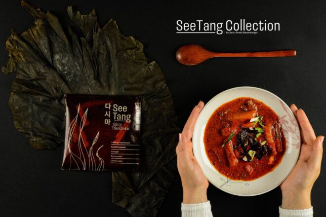 See-Tang biopackaging on the left side next to a red curry on a white plate on the right side of the image