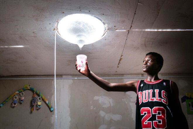 Boy holding up a cup to a solar desalination skylight