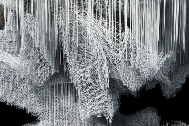 Installation piece composed of thousands of white linear components in front of a black background