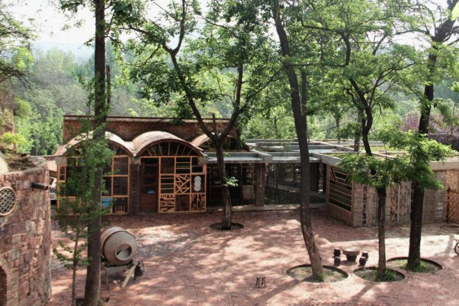 Prefabricated buildings made from recycled materials with patterned facades and some barrel vaulted ceilings and flat roofs