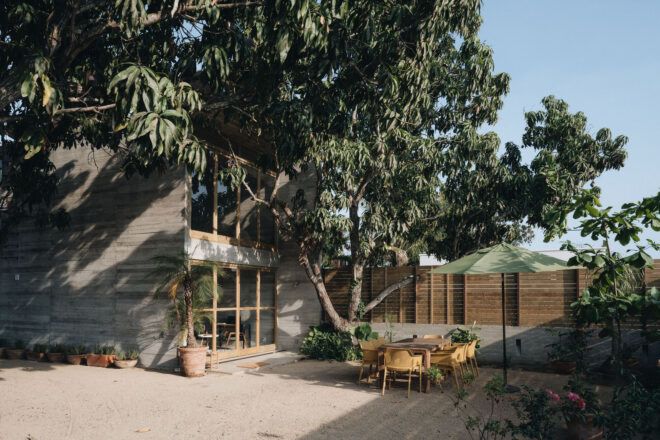 An courtyard enclosed within the fencing of the house has chairs and table