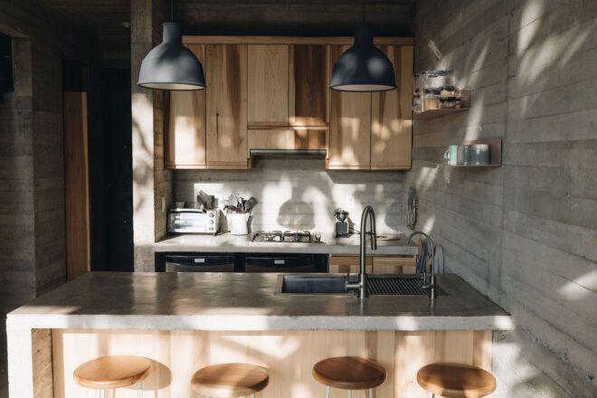 A kitchen space features wood furnishings and an island with wooden stools