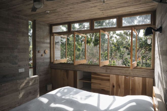 Interior bedroom has a wall of windows and cabinets
