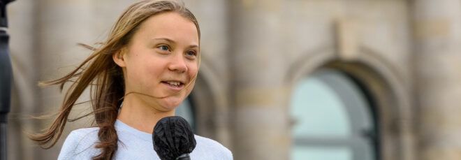 Greta Thunberg holding a microphone.