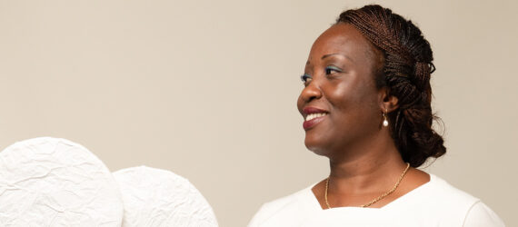 A woman with her face turned to the side wearing a white t-shirt.
