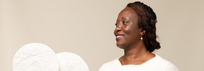 A woman with her face turned to the side wearing a white t-shirt.