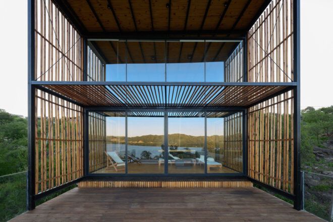 A two story wooden structure has multiple glass windows