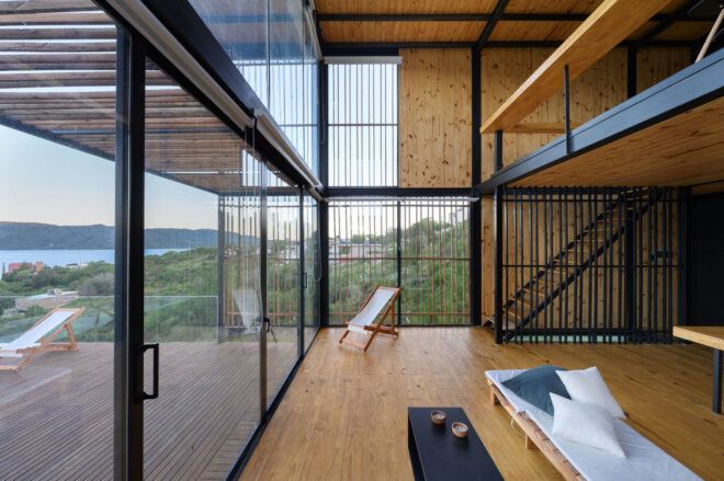 Interior downstairs of the bioclimatic house features glass panels all around